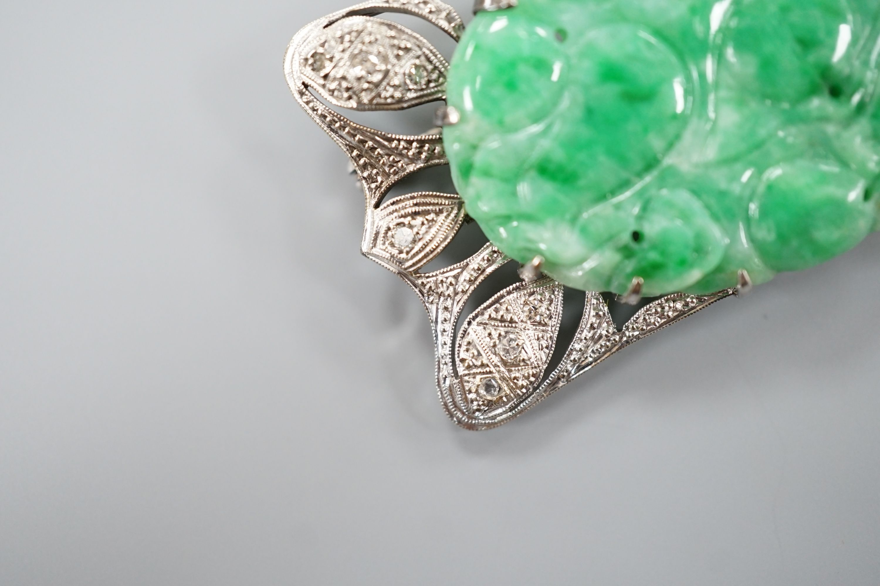 A white metal (stamped 9C?), diamond chips and oval carved jade set shaped rectangular brooch, 52mm, gross weight 13.1 grams.